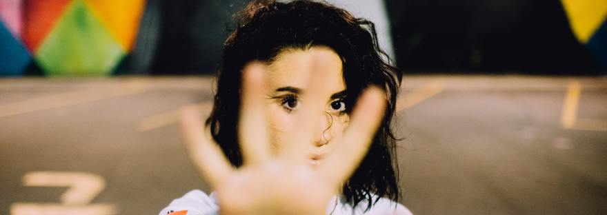 woman with hand held up in front of her face