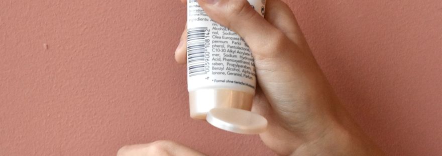 hand with bottle of sunscreen